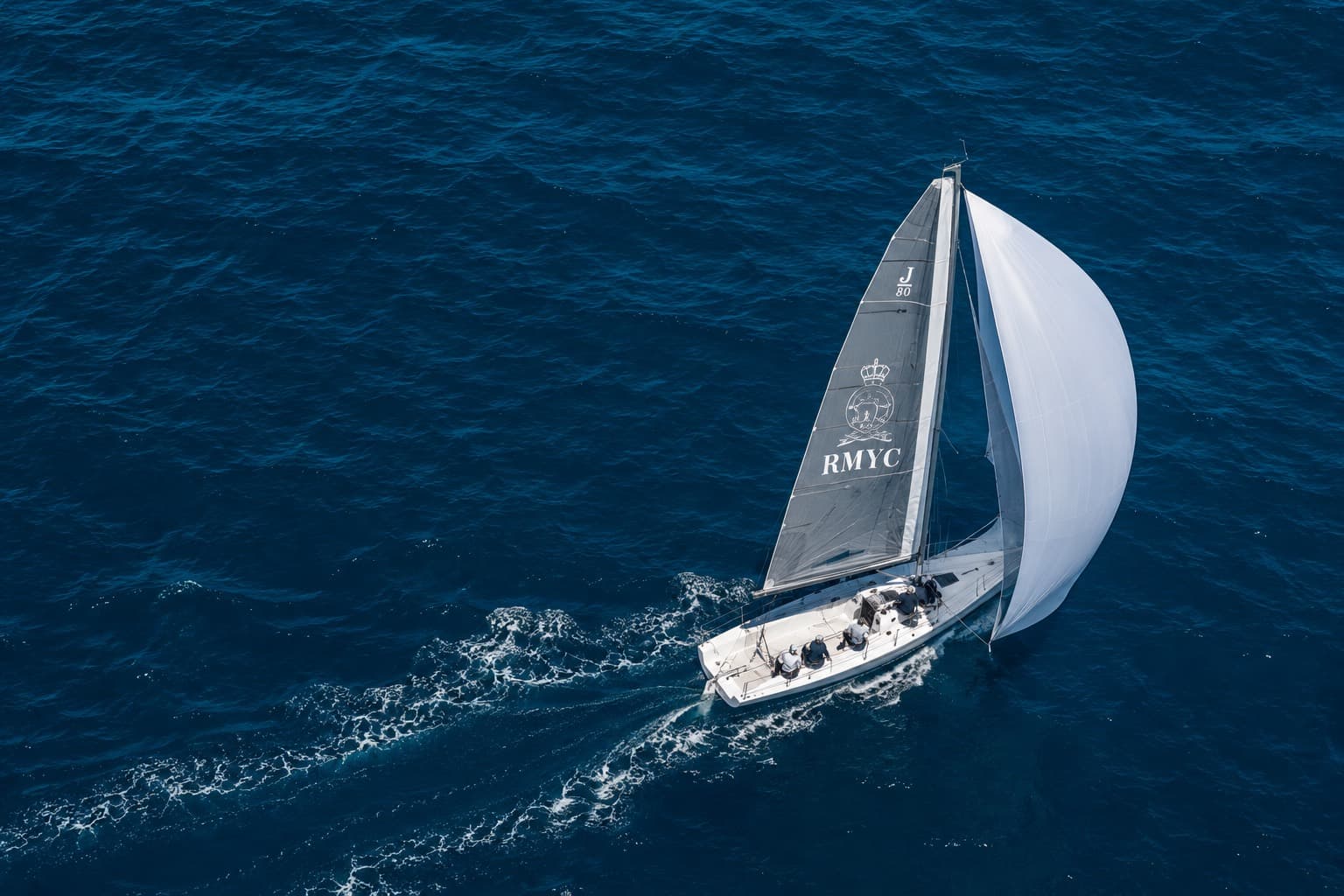 RMYC sailboat with white sails on the Bay of Bengal